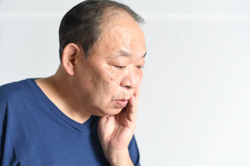 Obraz premium 頬を抑える中高年の男性