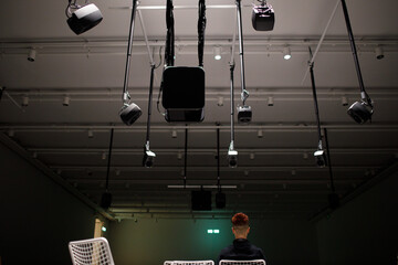Young man listening to sound music surround installation with many speakers above