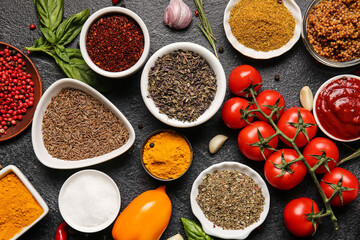 Composition with fresh aromatic spices and vegetables on dark background