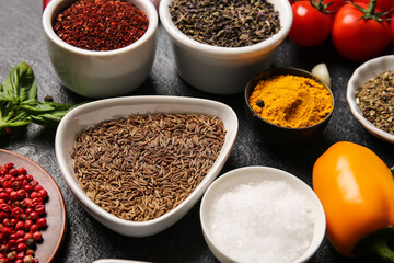 Bowls with fresh aromatic spices on dark background, closeup