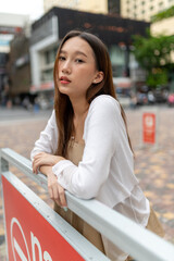 Lifestyle portrait photo of a beautiful young asian lady relax and posing around the city after a long pandemic lockdown