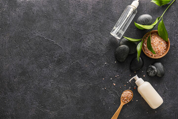 Plakat Composition with bottles of cosmetic products, spa stones and sea salt on dark background