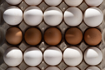 Egg background. White and brown eggs in a paper box tray. Protein food. Eco organic. Minimalism concept.