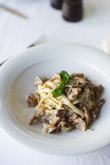 Appetizing Italian pasta with mushrooms on a light background.