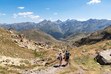 Fototapeta na wymiar Couple of hikers descending from Peyreget. Pyrenees National Park
