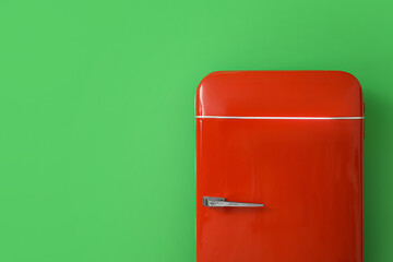 Stylish retro fridge near green wall