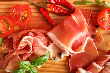 Wooden board with slices of delicious jamon, closeup
