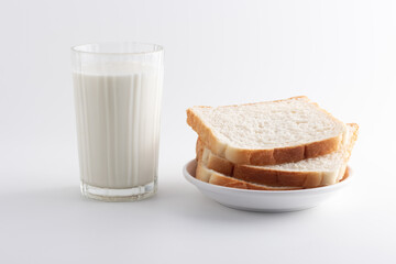 A Glass of milk and whole wheat sliced bread in a white plate for food and healthy concept with copy space for text isolated on white background