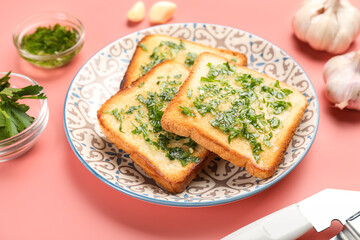 Plate with slices of toasted garlic bread on pink background, closeup