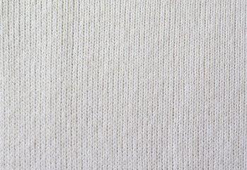 Knitted white pattern closeup. Soft sweater texture, detailed yarn background. Natural woolen fabric, a fragment of a jersey pullover. Trendy backdrop for print, web design.