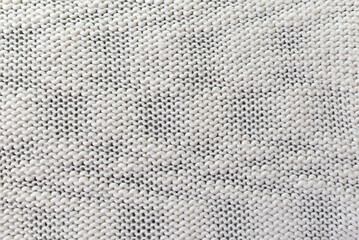 Knitted white pattern closeup. Soft sweater texture, detailed yarn background. Natural woolen...