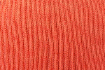 Knitted orange pattern closeup. Soft sweater texture, detailed yarn background. Natural woolen fabric, a fragment of a jersey pullover. Trendy backdrop for print, web design.