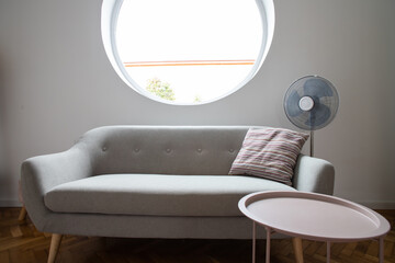 grey sofa in cozy living room with round window