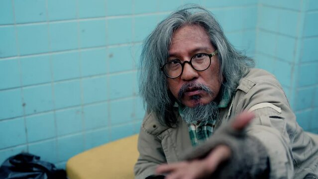 4K, Homeless man, notoriously busy, seeks help from passersby, starving with no food to eat from homelessness and joblessness. The poor man had no home to live streets.