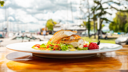 Layers of fish and vegetables on a plate at lake Balaton.