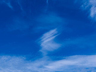 Niebo częściowo zachmurzone. Pokryte jest białymi, delikatnymi, pierzastymi chmurami, pomiędzy którymi widać błękit nieba. Jest słoneczny dzień. - obrazy, fototapety, plakaty