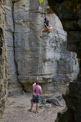 Teenage girl in a difficult rock climbing, secured by her dad in the rock gardens of Hessigheim, Neckar valley, Baden-Wuerttemberg, Germany