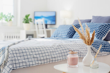 diffuser and  bouquet of dried plants in  vase in  bedroom in  sunlight