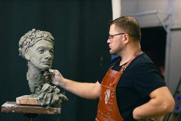 Man sculptor portrait sculpt bust clay human woman sculpture. Statue craft creation workshop.