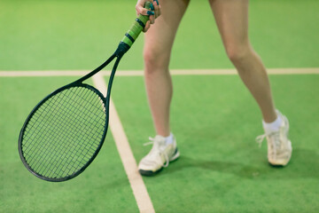 Tennis woman player legs playing training with racket and ball at court.