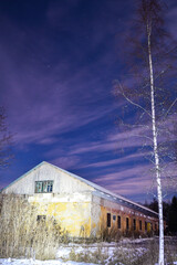 Winter sky and old barn at night