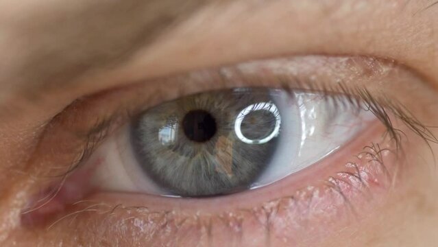 Closeup of blue male eye with contact lens looking at camera. Selective focus.