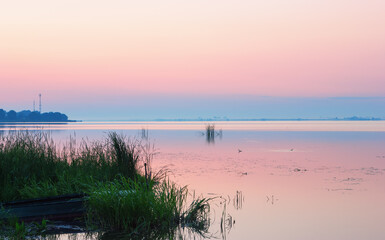 Gentle Pink Dawn Over the Blue Horizon of a Calm Lake - 524437623