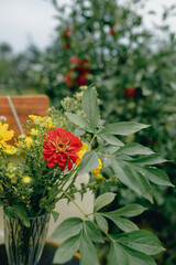 A small summer bouquet of yellow and red flowers found in the garden. Photo on a background of greenery.