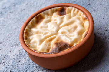 Baked rice pudding turkish milky dessert sutlac in earthenware casserole with hazelnuts