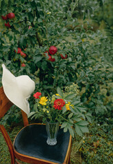 A small summer bouquet of yellow and red flowers found in the garden. Photo on a background of greenery.