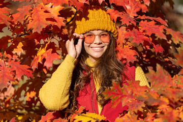 happy teen kid in sunglasses at autumn leaves on natural background