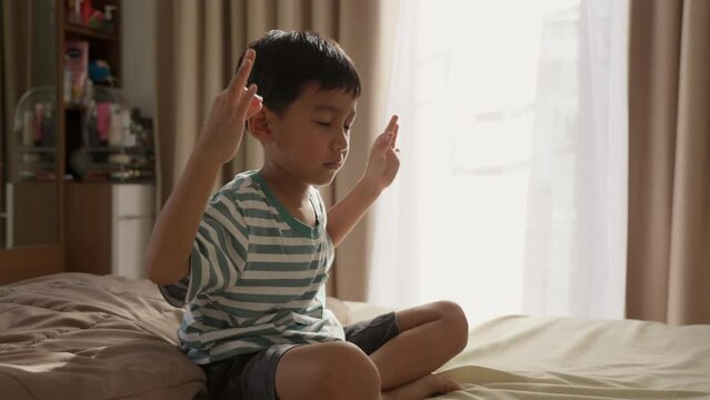 Asian Boy Meditating at Home, Child Mindfulness and Mental Wellbeing.