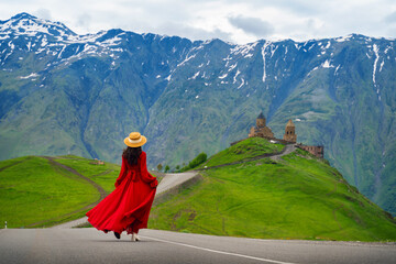 Tourist walking at Gergeti Trinity Church (Tsminda Sameba) in Kazbegi, Georgia.