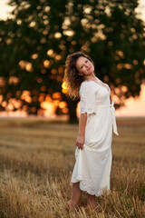 Caucasian woman in a field at sunset