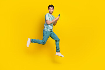 Fototapeta na wymiar Full body profile photo of funky guy run write telephone wear t-shirt jeans boots isolated on yellow color background