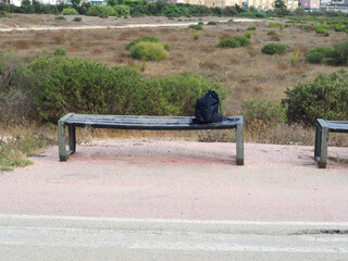 A blue sports bag lies on a wooden bench
