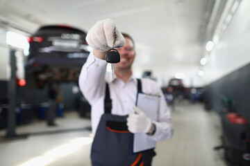 Auto mechanic holds clipboard and car keys