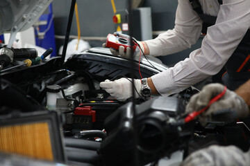 Fototapeta na wymiar Car repair technicians use voltage multimeter to work in auto repair shops
