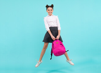 Back to school. Teenager schoolgirl in school uniform with bag. School children on isolated blue studio background. Jump and run. Happy teenager, positive and smiling emotions of teen girl.