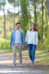 young couple walking in a park in autumn forest