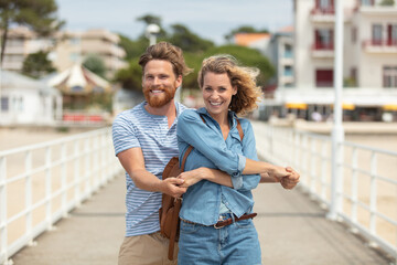 couple standing on beach pier embracing