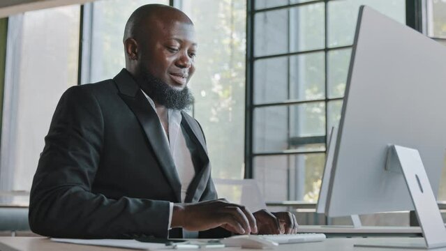 Middle aged business specialist african american man entrepreneur working on computer at office senior IT manager web designer programmer ceo agent trading online e-commerce check email data analysis