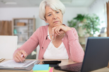 beautiful senior woman working with documents and laptop