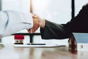 Real estate agents shake hands with customers after signing documents