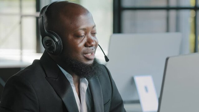 African american business person ceo consultant lawyer advisor recruiter hr manager in headphones with microphone talking at computer webcam consulting online interviewing distant negotiation remotely