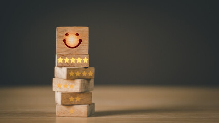 Concept customer service and satisfaction survey .Close-up ,icon smiley face and 5 stars on cube wood Comment or high rating potential assessment business popularity.