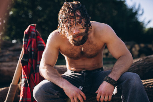 Man sitting on a log and drinking water in the forest