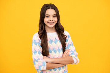 Portrait of caucasian teen girl with arms folded, isolated on yellow background. Cute teenager child.