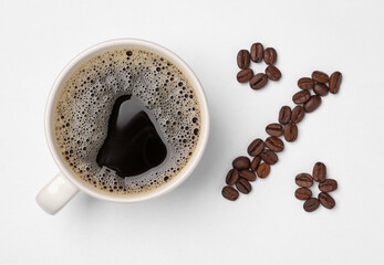 Cup of coffee and beans as percent sign on white background, top view. Decaffeinated drink