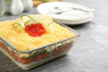 Traditional russian salad Mimosa served on grey table